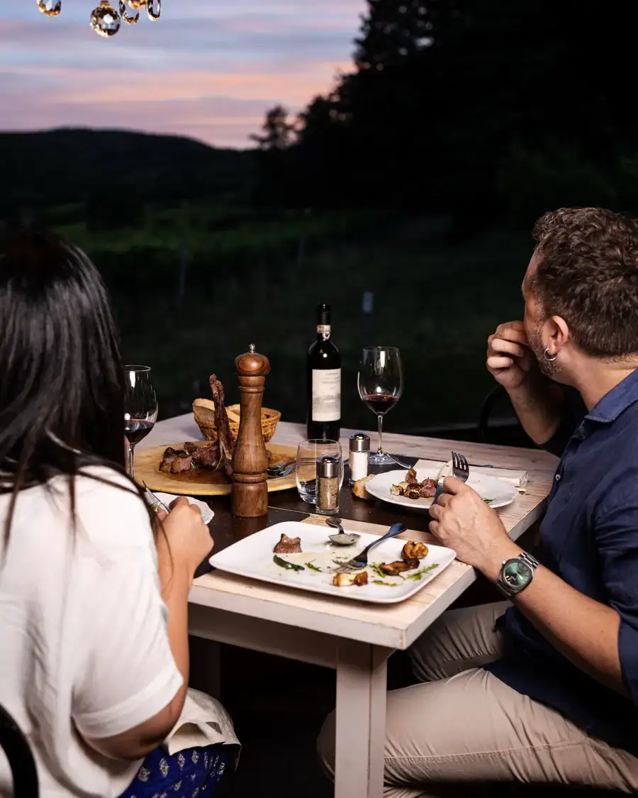 Coppia a cena in veranda al tramonto con vista sulle colline del Chianti