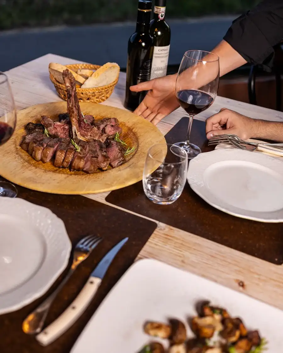 Il servizio al tavolo: la fiorentina portata sul tagliere di legno