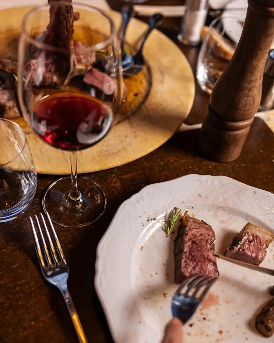 Tagliata di carne servita con un calice di vino rosso